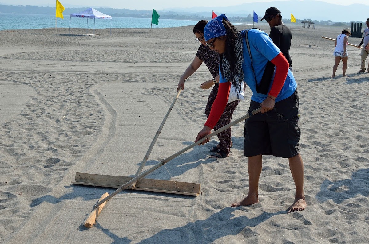 Artist AG Sano leading the creation of sand art.